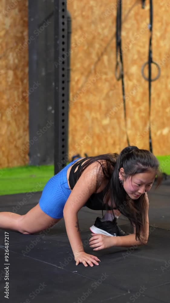 Vertical video of a female beauty fit Chinese athlete warming up in a cross training gym Vertical video of a female beauty fit Chinese athlete warming up in a cross training gym
