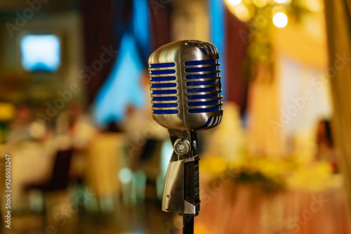 Tablou pe pânză Vintage microphone on a stand in a dimly lit banquet hall