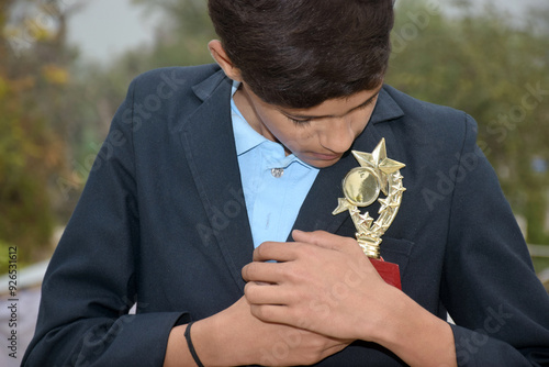 Indian handsome school boy with gold medal, school concept, selective focus