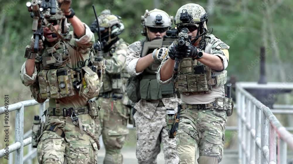 Soldiers in full gear and equipment move quickly into a combat zone with the enemy. In a military zone before military training or combat. Modern military gear and equipment in a new combat style. Soldiers in full gear and equipment move quickly into a combat zone with the enemy. In a military zone before military training or combat. Modern military gear and equipment in a new combat style.