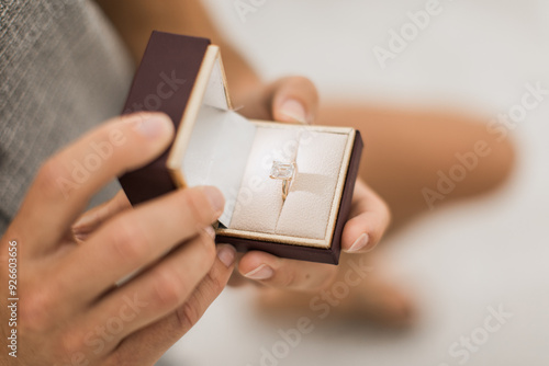 Foto Man proposing with a beautiful emerald cut diamond ring in a box