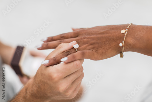 man proposing by putting a ring on a his fiancé's finger 