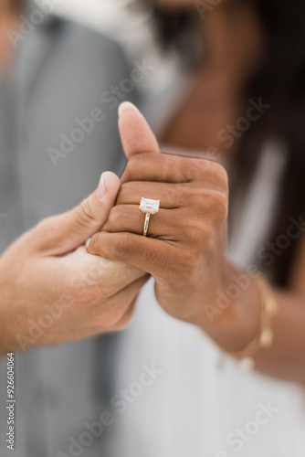 bride and groom holding hands showing engagement ring 