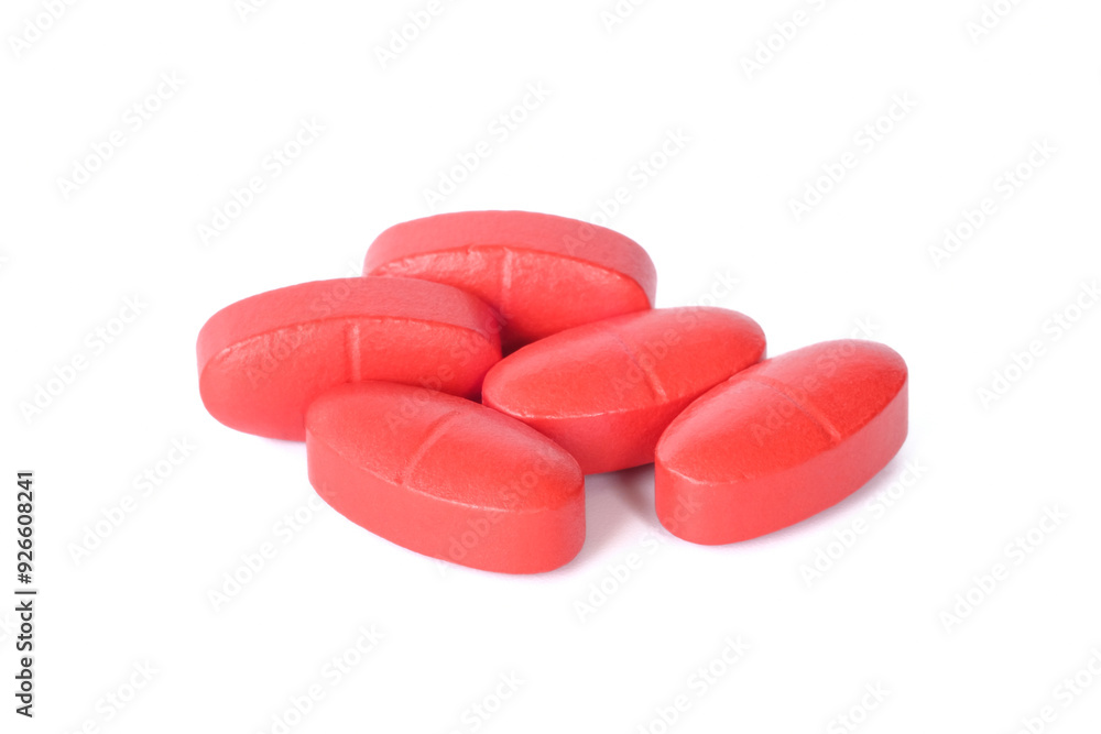 Red tablets oral medication close up on white background.