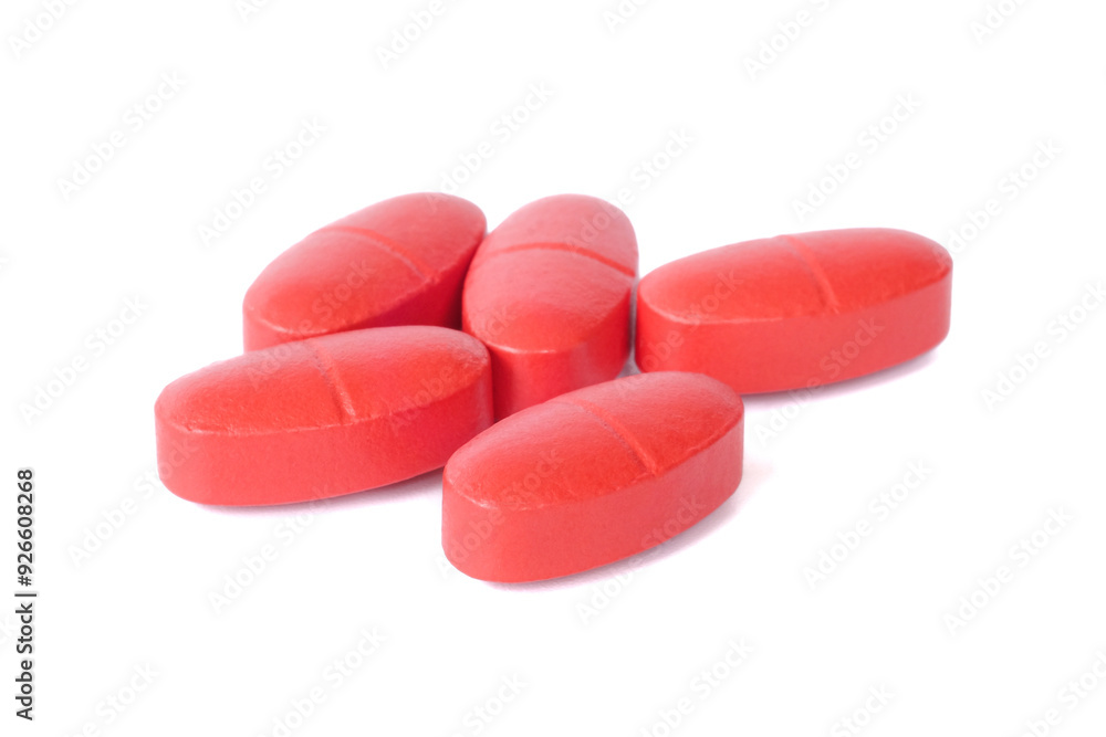 Red oral medication tablets close up on white background.