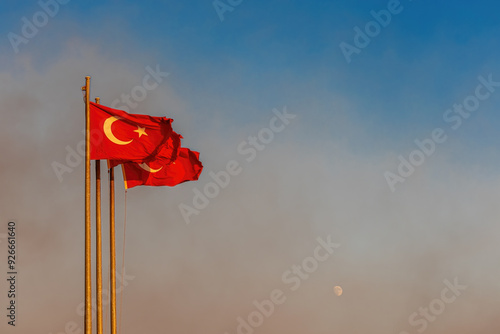Obraz na płótnie Turkish flag waving on the Izmir - Karşıyaka beach and the rising moon in the background. w salonie