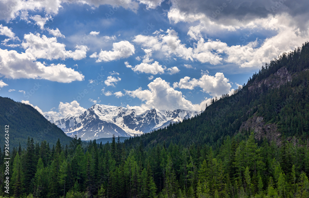 snow mountains between green ones under white clouds snow mountains between green ones under white clouds