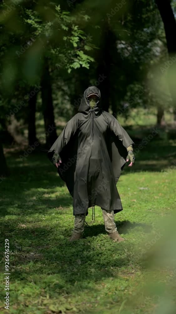 A soldier in a military camouflage cloak. The soldier is dressed in a camouflage uniform and a raincoat. Ukrainian army soldier. Defender of the country A soldier in a military camouflage cloak. The soldier is dressed in a camouflage uniform and a raincoat. Ukrainian army soldier. Defender of the country