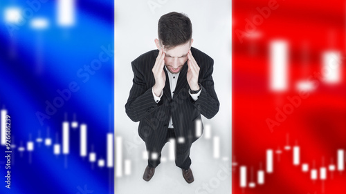 Upset french business man. France flag. Sad investor. Crisis and inflation in France. Trader guy is upset. Crisis in France. Businessman suffers from recession. Man against backdrop of crisis graph. photo