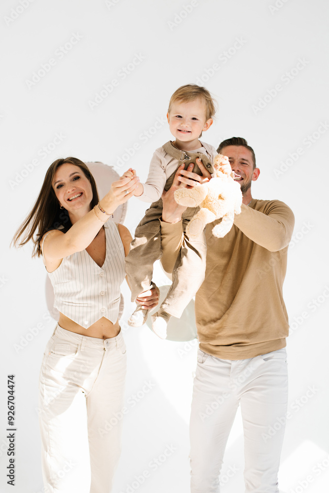 Happy family has fun together. Dad lifts his son up in his arms, and mom smiles Happy family has fun together. Dad lifts his son up in his arms, and mom smiles