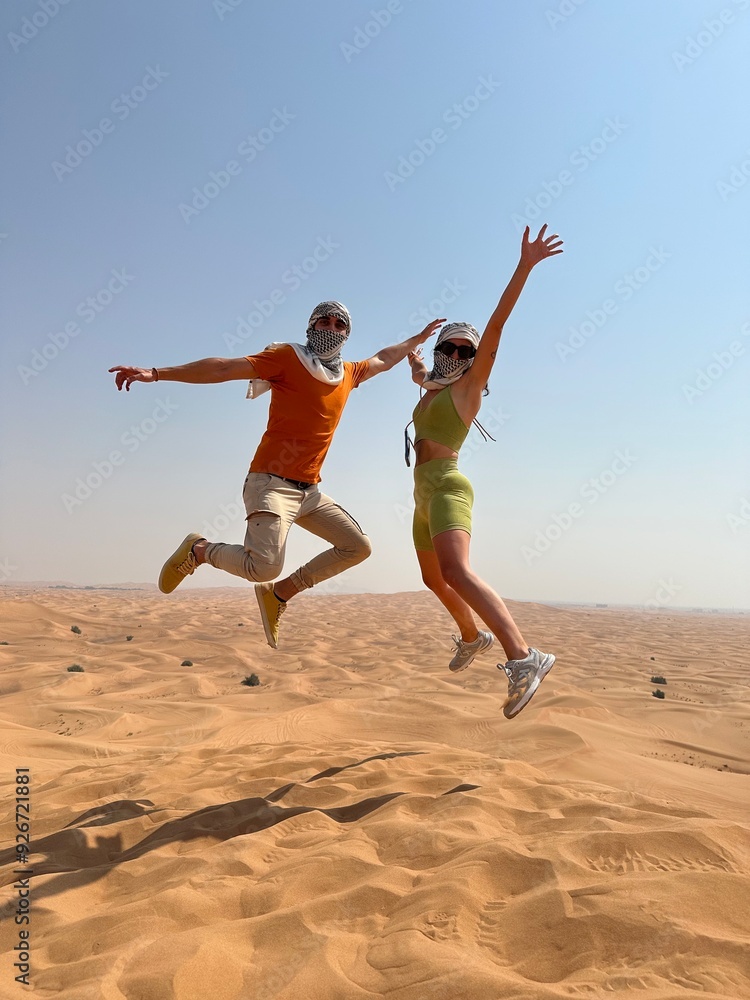 Pareja saltando en el desierto de Dubai Pareja saltando en el desierto de Dubai