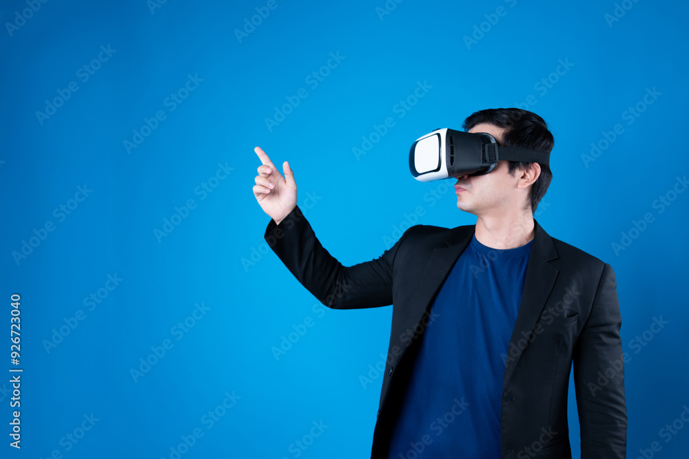 Profile businessman wearing VR headset looking to connect metaverse pointing to choose interesting data isolated blue background futuristic analytics communication tech virtual reality. Contrivance. Profile businessman wearing VR headset looking to connect metaverse pointing to choose interesting data isolated blue background futuristic analytics communication tech virtual reality. Contrivance.