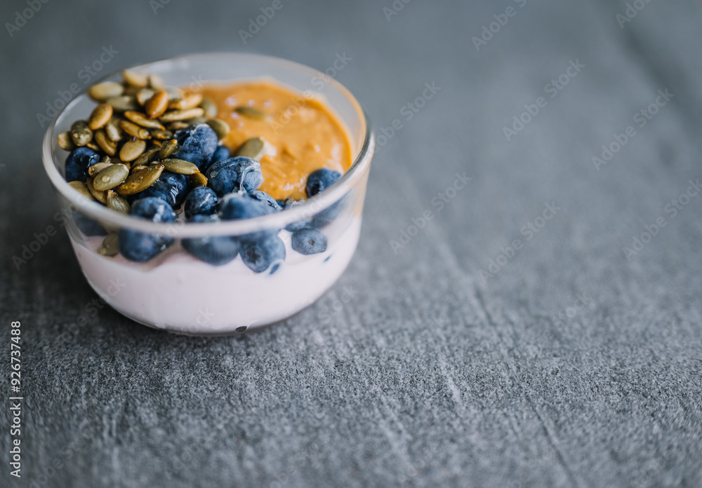blueberries in a glass bowl with nuts and peanut butter drizzled with honey blueberries in a glass bowl with nuts and peanut butter drizzled with honey