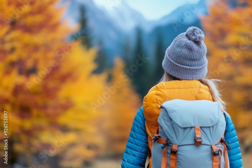 Hiker taking pictures in a vibrant autumn forest with orange leaves