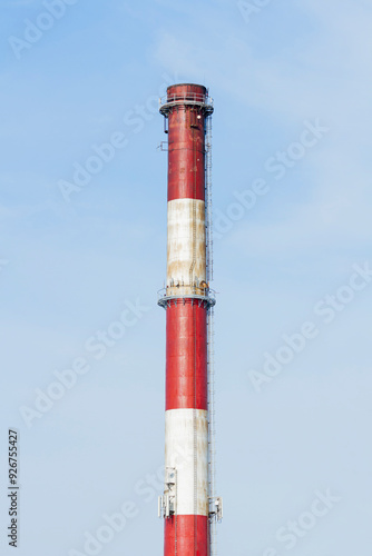 An industrial chimney against a clear sky, painted white and red | Komin przemysłowy na tle czystego nieba, pomalowany na biało-czerwono