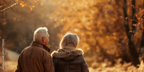 Senior Couple Walking in Autumn Park Enjoying Beautiful Fall Foliage photo