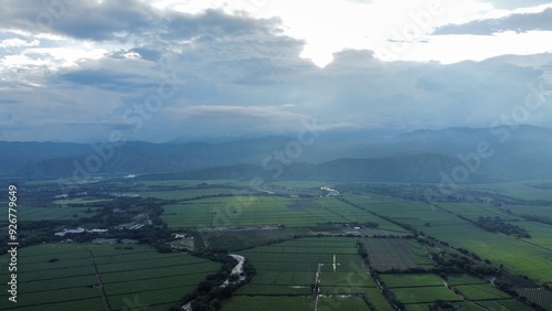 Aerial View of Valle del Cauca with Green Crops Illuminated by Sunrise, Clouds, and Mountains