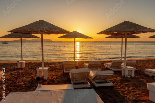 View of tropical beach with umbrelles during sunset. Holiday vacation and travel concept. photo