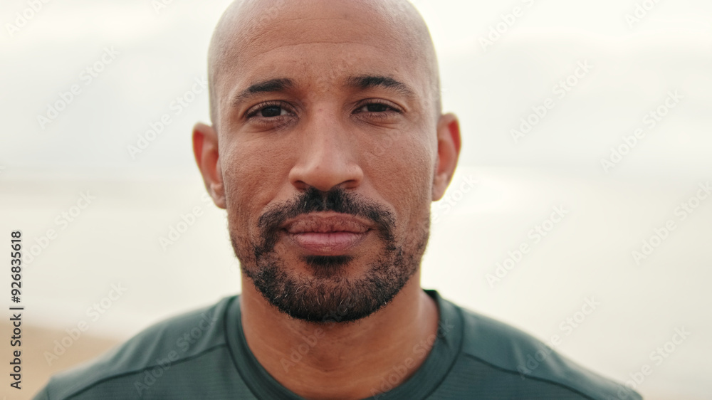 Close-up portrait of calm mindful athletic man and on the blurred background of the sea Close-up portrait of calm mindful athletic man and on the blurred background of the sea