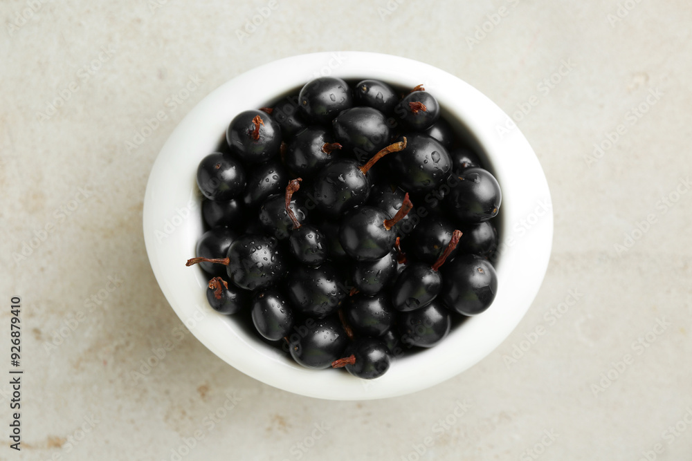 Ripe black currants in bowl on light table, top view Ripe black currants in bowl on light table, top view