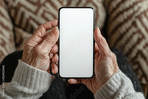 An older woman is holding a cell phone with a white screen