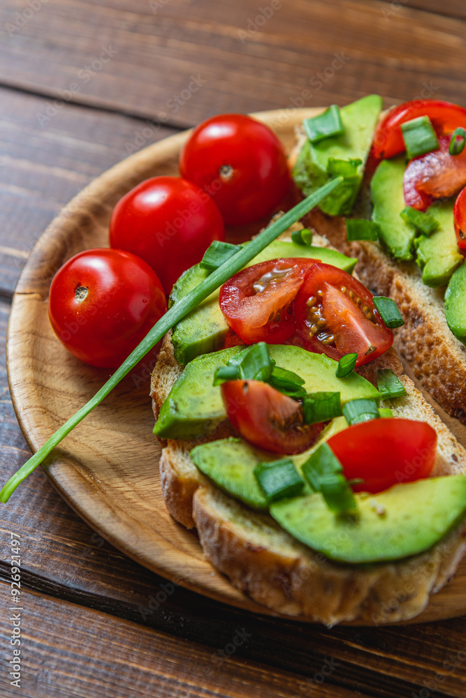 Avocado toast topped with tomato and green onion on a slice of carrot bread Avocado toast topped with tomato and green onion on a slice of carrot bread