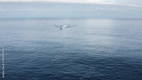 Flying by a fishing boat in the open ocean at sunrise