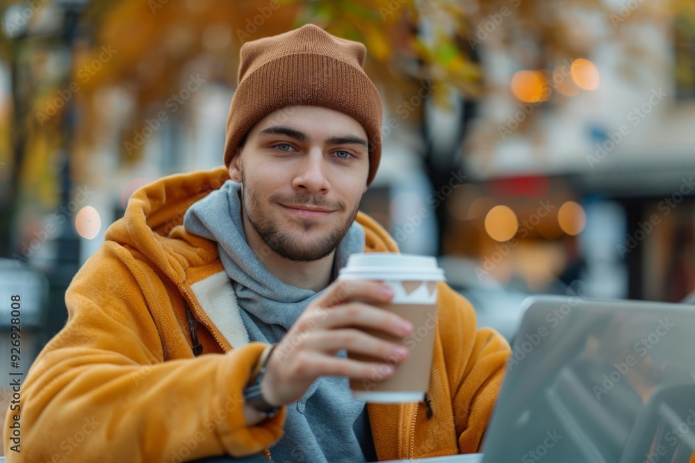 Young Man in a Knit Hat Enjoying a Coffee in the City Young Man in a Knit Hat Enjoying a Coffee in the City
