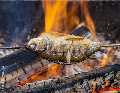 fish being grilled on burning firewood. generative ai photo