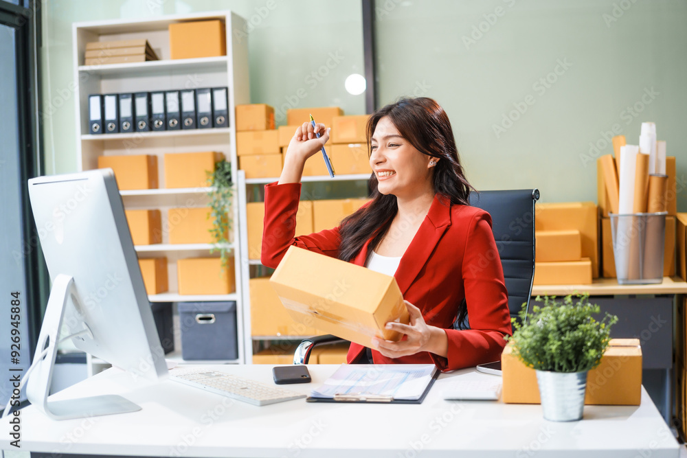 A beautiful businesswoman sits at the table, looking at the computer screen and talking on the phone. She analyzes marketing plans with a smile, feeling happy and successful in her online business. A beautiful businesswoman sits at the table, looking at the computer screen and talking on the phone. She analyzes marketing plans with a smile, feeling happy and successful in her online business.