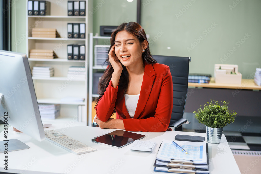 An Asian businesswoman sits at the table, working long hours as a financial analyst on computers tablets.experiences office syndrome symptoms like neck pain, headaches, stress,other health issues. An Asian businesswoman sits at the table, working long hours as a financial analyst on computers tablets.experiences office syndrome symptoms like neck pain, headaches, stress,other health issues.