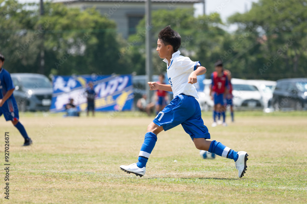 Obraz premium サッカーの試合をする小学生の男の子