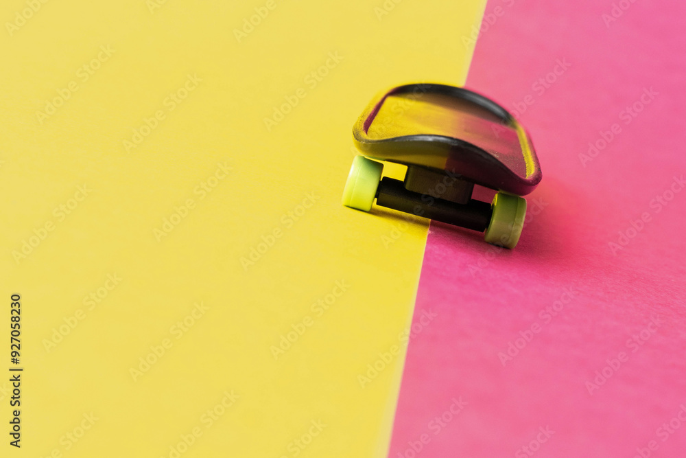 Mini Skateboard on Vibrant Pink and Yellow Background