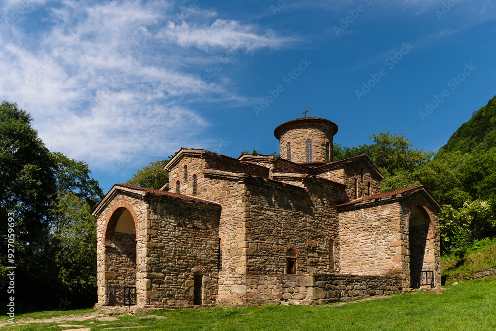 Fototapeta premium Ancient stone church set in green valley