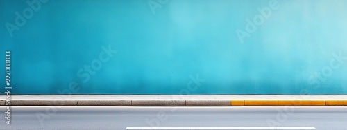  A white fire hydrant stands beside a road, adjacent to a blue wall with a yellow stripe