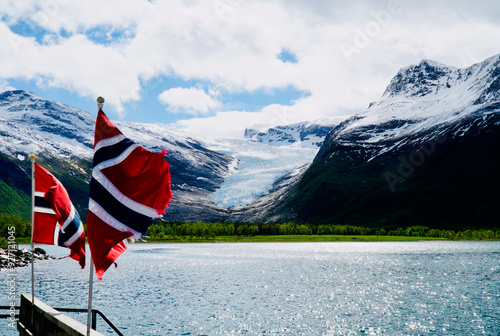 View of Svartisen glacier from boat with Norwegian flag