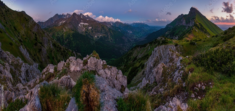 Obraz premium Evening twilight in Mountain landscape. View on Tatra Mountains National Park with remains of snow on peaks on colorful sunset. Belianske Tatry, Tatry Bielskie. Border of Poland and Slovakia.