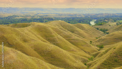 Landschaft nahe Waingapu in Sumba Indonesien mit braunen grasigen Bergen in der Trockenzeit