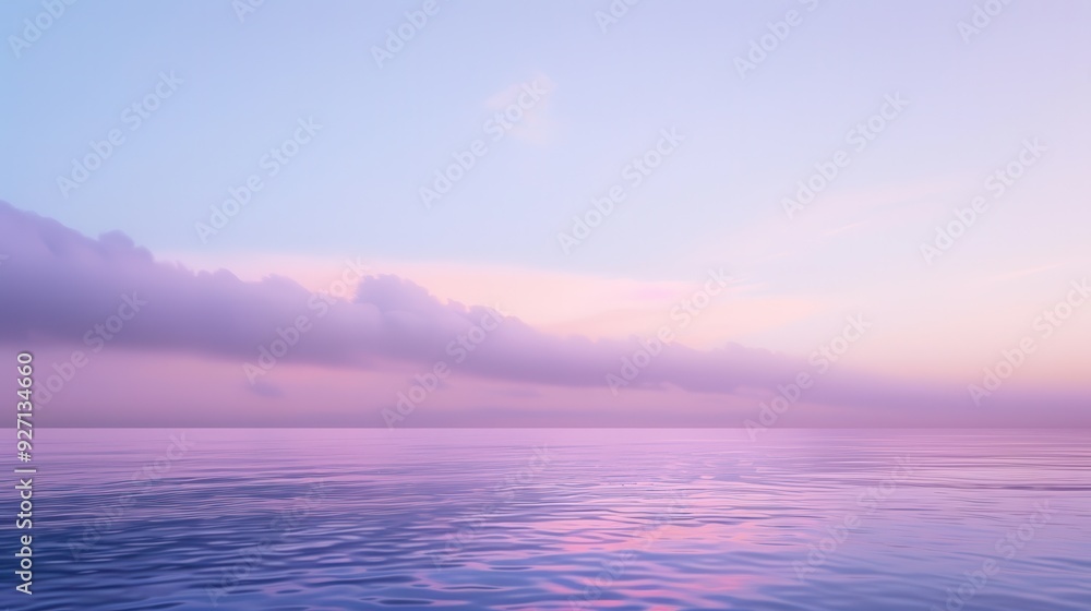 Obraz premium The sky is a soft lavender color, transitioning into a pink hue near the horizon. The water is calm and reflecting the colors of the sky. The sun is just beginning to rise, casting a warm glow on the 