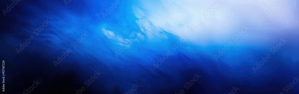 Obraz premium An abstract image with soft, blue and white swirls, fading into a blurred background. The image is reminiscent of water or smoke, creating a sense of movement and depth.