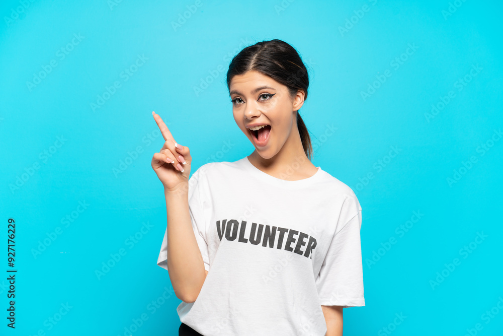 Young Russian volunteer girl isolated on blue background intending to realizes the solution while lifting a finger up Young Russian volunteer girl isolated on blue background intending to realizes the solution while lifting a finger up