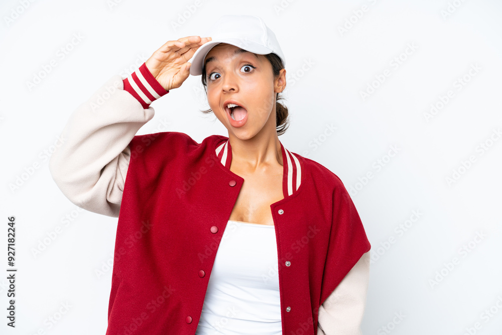Young hispanic woman wearing a baseball uniform isolated on white background doing surprise gesture while looking to the side Young hispanic woman wearing a baseball uniform isolated on white background doing surprise gesture while looking to the side