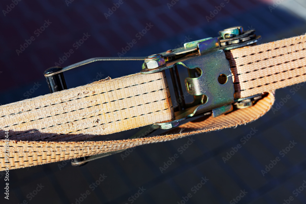 Cargo strap is attached to a metal belt. Buckle and the texture of the belt material