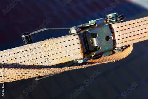 Obraz na płótnie Cargo strap is attached to a metal belt. Buckle and the texture of the belt material w salonie