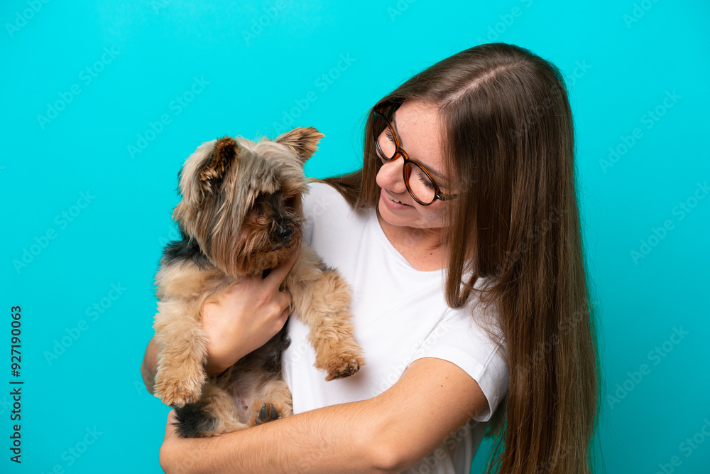 Young Lithuanian woman holding a dog isolated on blue background Young Lithuanian woman holding a dog isolated on blue background