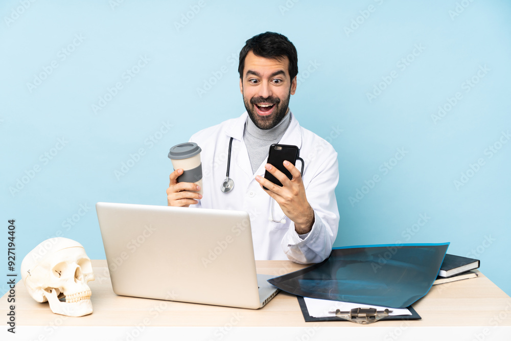 Professional traumatologist in workplace holding coffee to take away and a mobile Professional traumatologist in workplace holding coffee to take away and a mobile