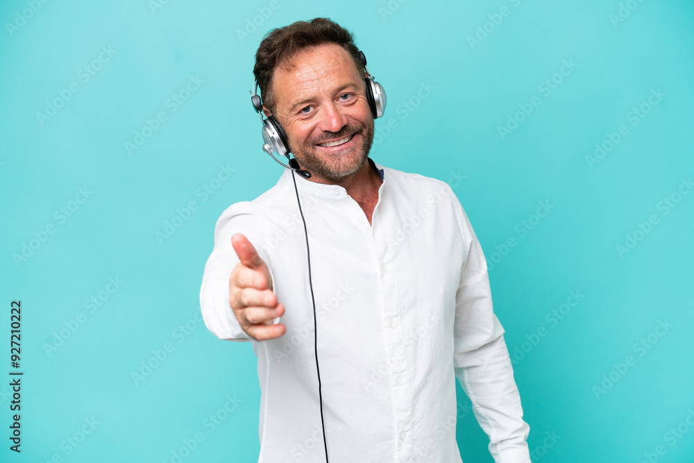 Telemarketer caucasian man working with a headset isolated on blue background shaking hands for closing a good deal Telemarketer caucasian man working with a headset isolated on blue background shaking hands for closing a good deal