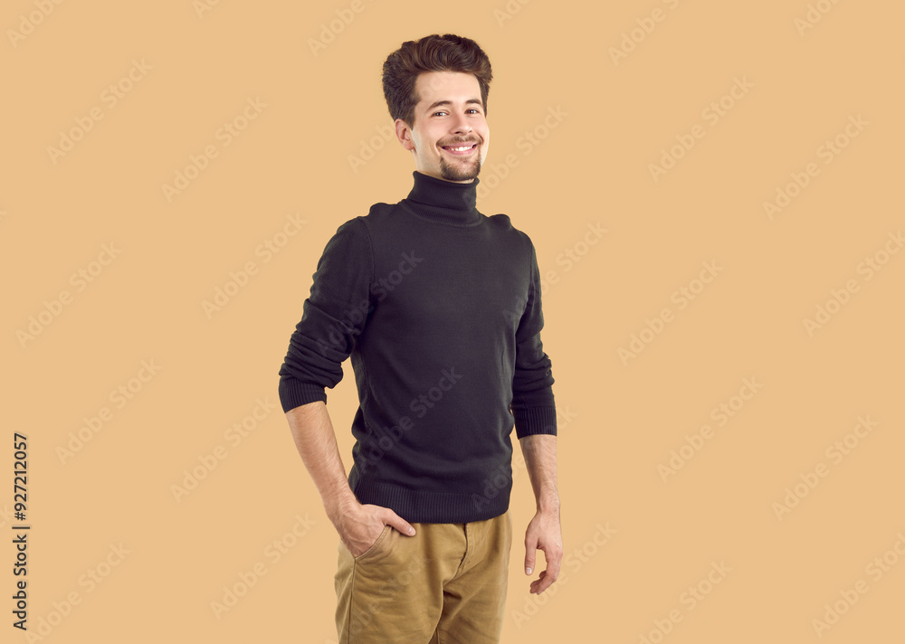 Portrait of happy confident bearded brunet guy in black turtleneck on beige background looking at camera. His hand is in the pocket of pants. Banner for advertisement, marketing. Sincere emotions. Portrait of happy confident bearded brunet guy in black turtleneck on beige background looking at camera. His hand is in the pocket of pants. Banner for advertisement, marketing. Sincere emotions.