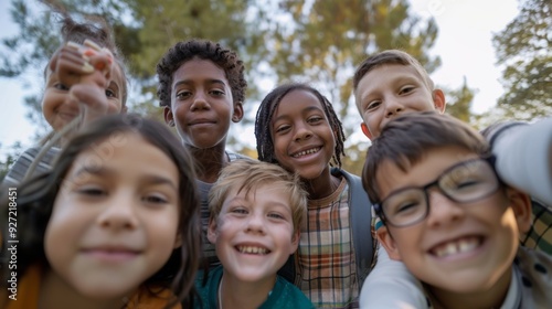 A group of diverse kids stands close together, beaming with excitement and happiness, with lush greenery in the background on a sunny day.