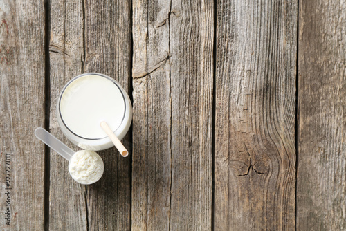 Принти на полотні Delicious protein shake in glass and scoop with powder on wooden table, top view